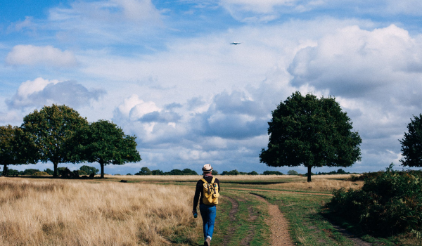 A photo of a person walking outdoors in nature. 