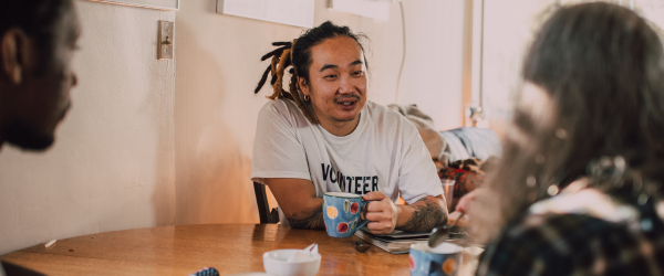 Man sitting across table from friends drinking coffee