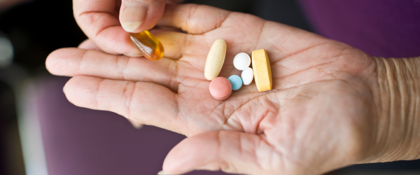 An outstretched hand with medication tablets on it