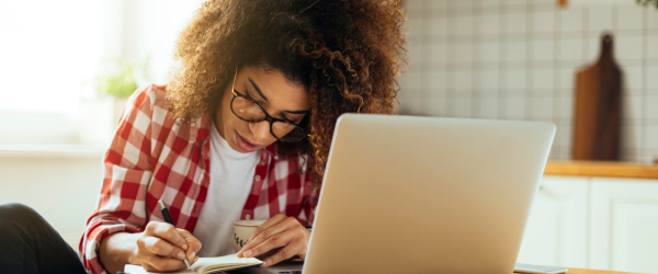 A woman at a laptop calculating bills